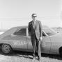 Photograph: [Budd Kneisel standing in front of WBAP car]