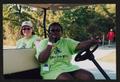 Photograph: [Volunteer duo riding in a golf cart: Lone Star Ride 2002 event photo]