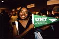 Photograph: [Student poses with new UNT pennant]