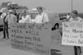 Photograph: [Three men holding signs at the Branch Davidian Annual Reunion]