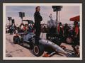 Photograph: [Eddie Cheever standing on the wheel of his car]