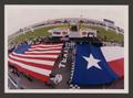 Photograph: [The United States and Texas State flags being unfurled]