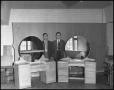 Photograph: [Two Men Standing With Handmade Vanity Desks]