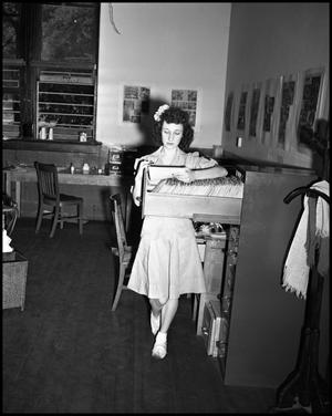 Primary view of object titled '[Woman looking through records in Campus Chat office]'.