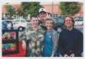 Photograph: [Four people smiling in a parking lot]