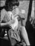 Photograph: [Mother Nursing Baby in Bedroom]