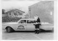 Photograph: [Andy Anderson in City of Denton Police Car with Presents; Santa Clau…