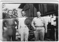 Photograph: [Three men pose by the CCC camp bulletin board]