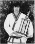 Photograph: Student Showing His Karate Trophy and Medal