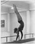 Photograph: Gymnastics Student Performing Handstand on Balancing Bar