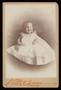 Photograph: [Portrait of a Smiling Infant in a White Gown]