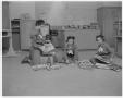 Photograph: [Girl Scouts sitting on a floor looking at magazines and books]