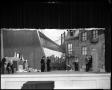 Photograph: [Actors performing in front of a cityscape drama set]