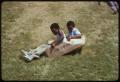 Photograph: [Visitors Sliding Down Berm at Institute of Texas Cultures]