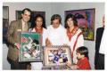 Photograph: [Four People Presenting Two Artworks]