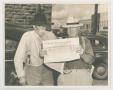 Photograph: [Two Men Holding Up Newspaper]