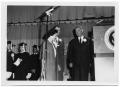 Photograph: [Lady Bird and Lyndon Johnson on a Stage with Graduates]