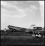Photograph: [Airplane in a Field with Three Cars and a Man]