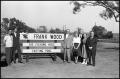 Photograph: [Frank Wood and Group Pose Around Fishing Pond Sign]