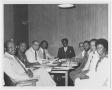 Photograph: [A Group of People Sit Around a Table]
