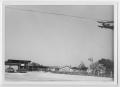 Photograph: [Photograph of an Airplane Flying of C. B. Hodge Livestock Company]
