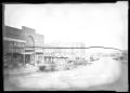 Photograph: [Photograph of a Row of Businesses and Automobiles]
