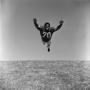 Photograph: [Football player #70, Jimmy Franklin, mid air tackle]
