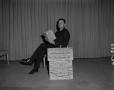Photograph: [Wane Brown sitting on chair with book]