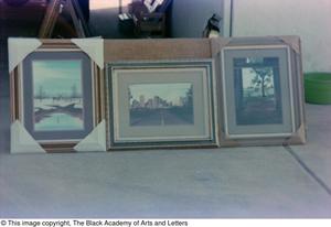 Primary view of [Photograph of three of James Edward Kemp's art works displayed outside of a garage]