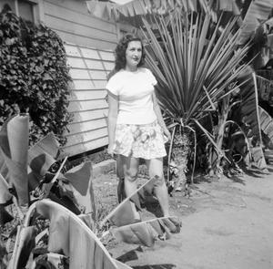 Primary view of [Photograph of Doris Stiles Williams posing near plants]