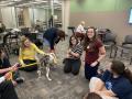 Photograph: [Maren Garcia and Abigail Mueller with therapy dog]