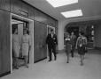Photograph: [People standing by elevators at Apparel Mart]