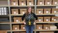 Photograph: [Amy San Antonio standing in front of archival boxes]