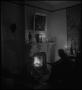 Photograph: [Sitting by fireplace]