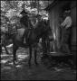 Photograph: [Boy getting off of a mule]