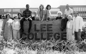 Primary view of Students and staff pose around a Lee College sign.