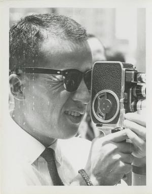 Photograph of a man with a camera at a 1964 Dallas civil rights protest