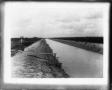 Photograph: [Photograph of Dirt Canal with Gate]