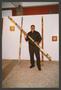 Photograph: [Alonzo Davis Holding Decorated Wooden Pole]