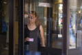 Photograph: [Woman walks through revolving door of JPS]