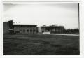Photograph: [View of Buildings Across Grassy Field]