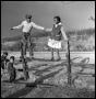 Photograph: [Bailey Woods and Sue Antoinette Emory Standing on Fence]