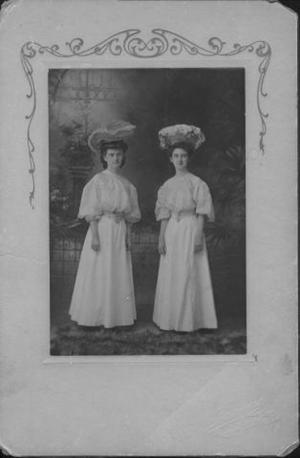 Primary view of [Two young women standing in long white dresses]