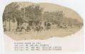 Photograph: [Photograph of Couples Driving Automobiles Down a Street]
